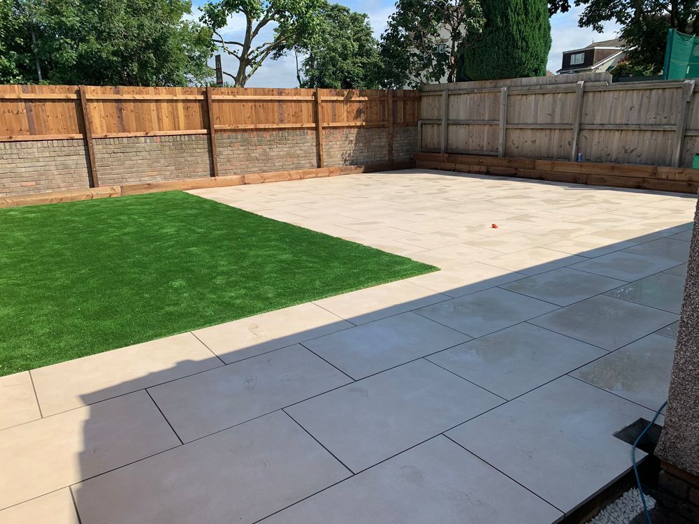 Paved patio beside a green lawn and timber boundary fencing