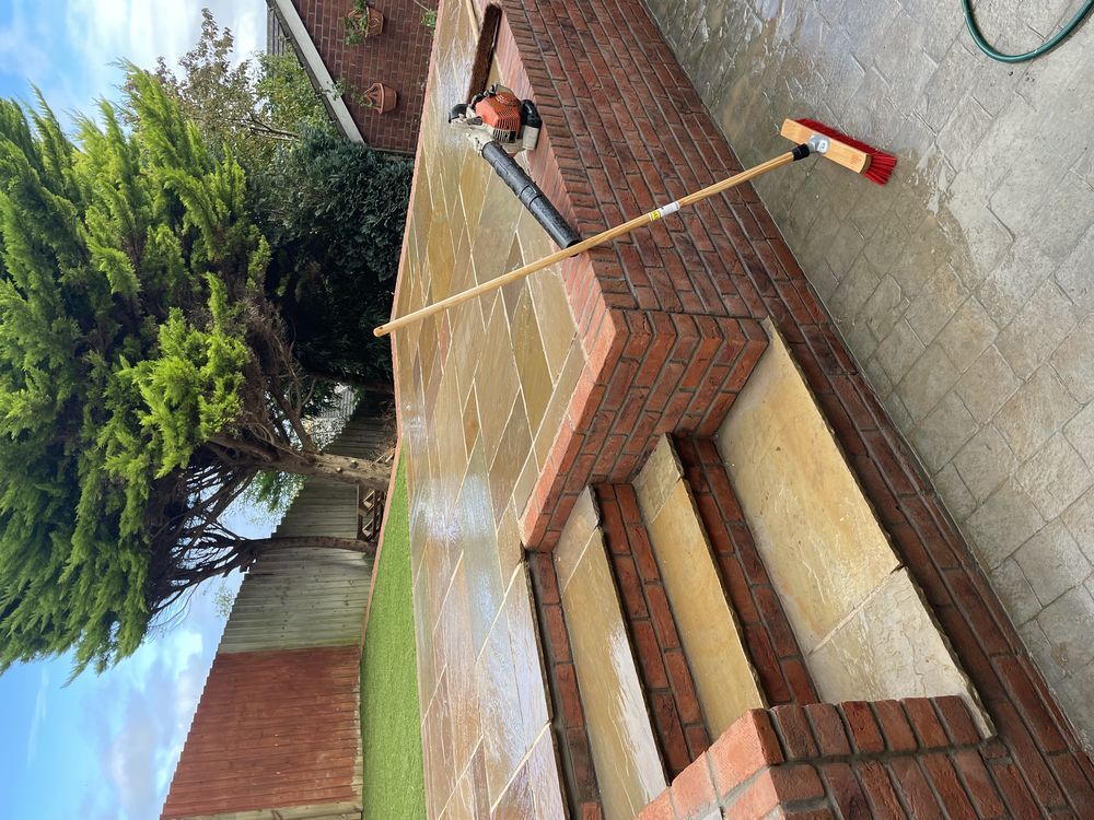 Paved garden area with brick-edged steps and timber fencing